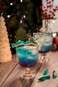 Two shark attack cocktail beverages garnished with shark shaped gummy candies.