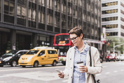 Usa, new york city, woman in manhattan looking on cell phone
