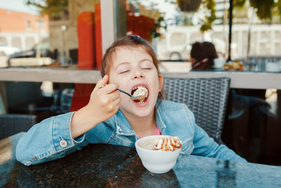 Close-up of girl eating ice cream at restaurant