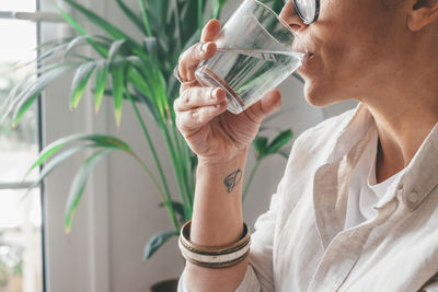 Midsection of woman drinking water