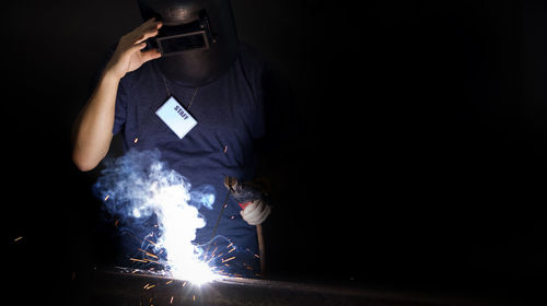 Blurred motion of man holding illuminated lighting equipment