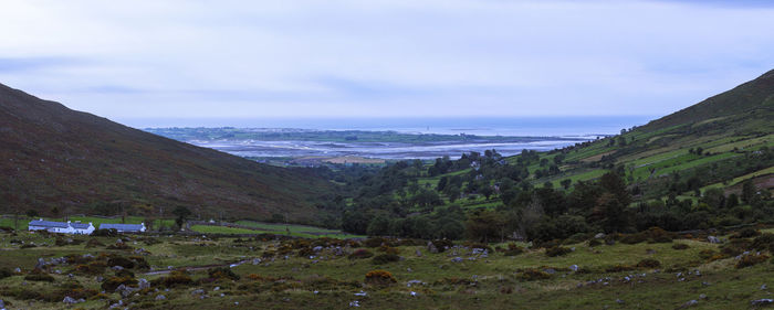 Scenic view of sea and mountains against sky