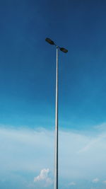 Low angle view of floodlight against blue sky