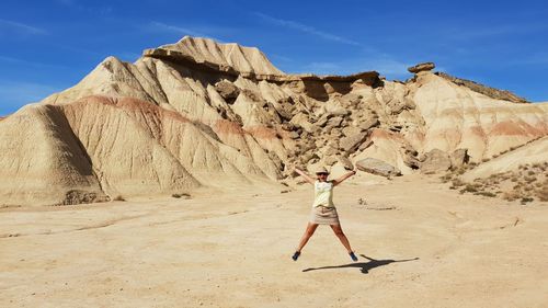 Woman standing on mountain against sky