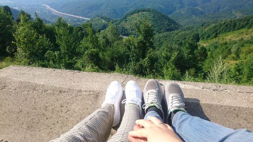 Low section of people relaxing on land against mountains