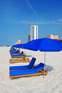 Blue sun loungers with canopies in row on shore