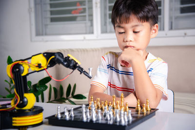 Close-up of young woman playing chess at home