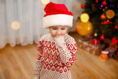 Beautiful boy found presents under the christmas tree.