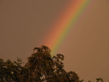 Low angle view of rainbow against sky during sunset