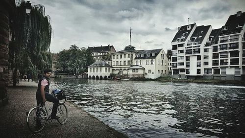 Man with bicycle in front of cityscape