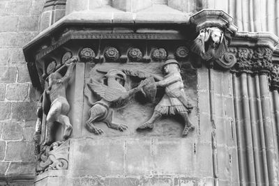 Low angle view of statue against old building