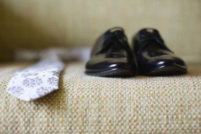 Necktie and shoes on sofa at home