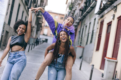 Happy female friends walking in city