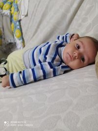 Portrait of cute boy lying on bed
