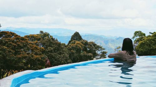 Woman in swimming pool against sky