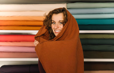 A charming woman enveloped in warmth and creativity in a textile shop, creative design concept