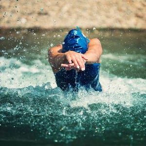 Man splashing water in swimming pool