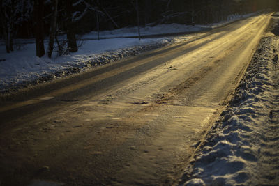 Road is in sunlight. winter track. light on roadway. sunset light.