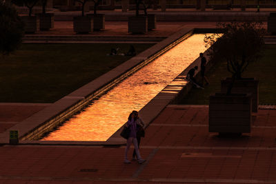 High angle view of woman walking on footpath at night