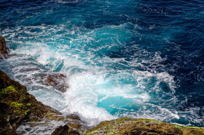 Incoming waves rushing at the rocky bay known as buracona