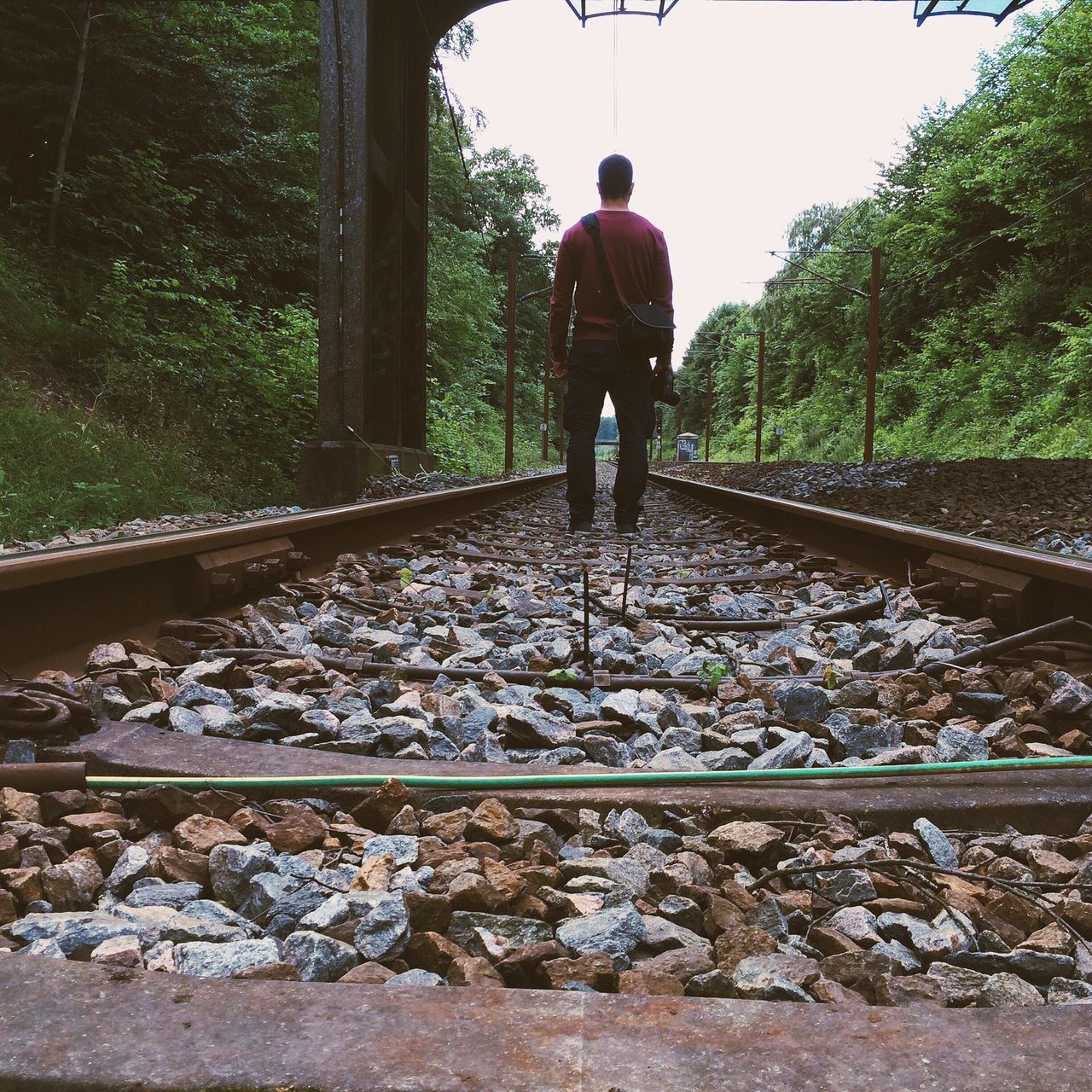 railroad track, full length, rail transportation, lifestyles, men, rear view, transportation, railing, tree, walking, leisure activity, standing, public transportation, the way forward, casual clothing, day, person, travel