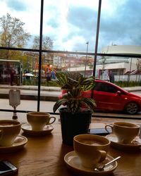 Coffee cup on table at cafe against sky