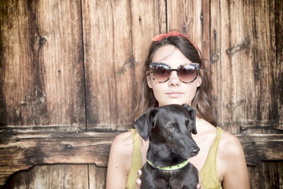 Portrait of young woman wearing sunglasses sitting outdoors