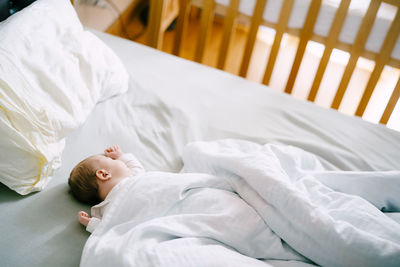 High angle view of boy resting on bed at home