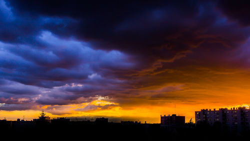 Storm clouds over city during sunset