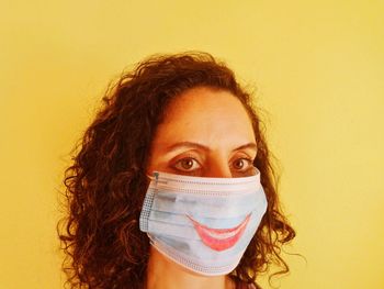 Portrait of woman against yellow wall