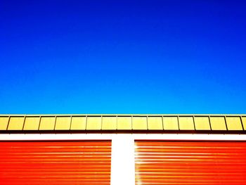 Low angle view of trees against clear blue sky