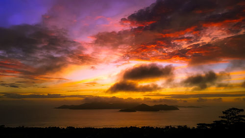 Scenic view of sea against dramatic sky during sunset