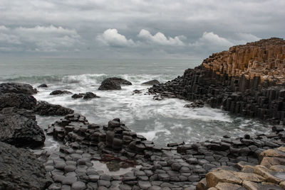 View of rocky beach against clouds