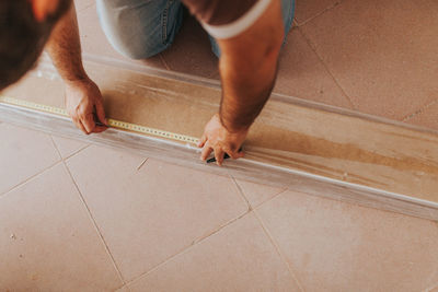 Midsection of man working on hardwood floor at home