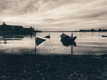 Sailboats in lake against sky during sunset