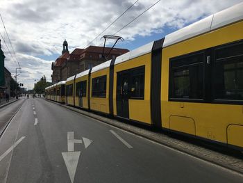 Train on road against sky in city