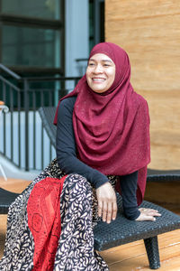Smiling woman looking away while sitting on chair