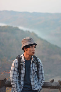 Young man standing against mountain