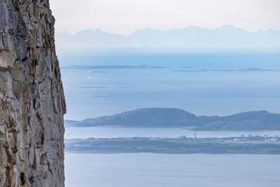 Scenic view of sea and mountains against sky