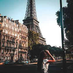 Woman tower against sky in city