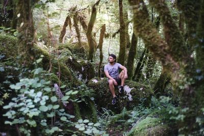 Full length of woman standing by plants in forest