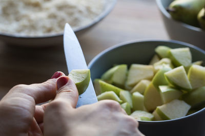 Close-up of hand cutting pear