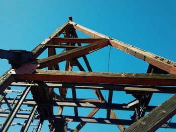 Low angle view of metallic structure against clear blue sky