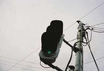 Low angle view of telephone pole against clear sky