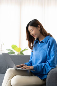 Young woman using laptop at home