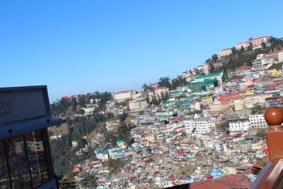 Buildings in city against clear blue sky