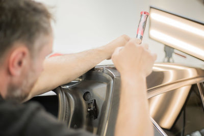 Close-up of man repairing car