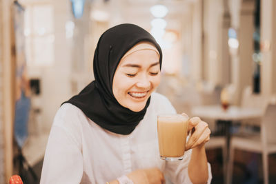 Portrait of a young woman drinking coffee