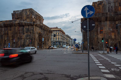 Cars on road in city against sky