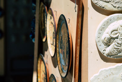 Close-up of old plates hanging on wall